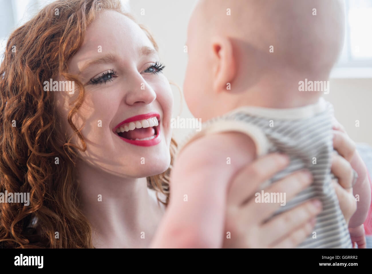 La donna caucasica holding baby figlio faccia a faccia Foto Stock