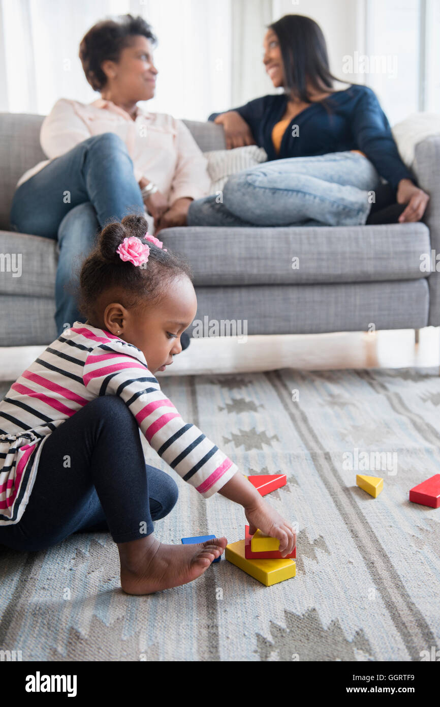 Black Baby girl giocare su un tappeto con blocchi Foto Stock