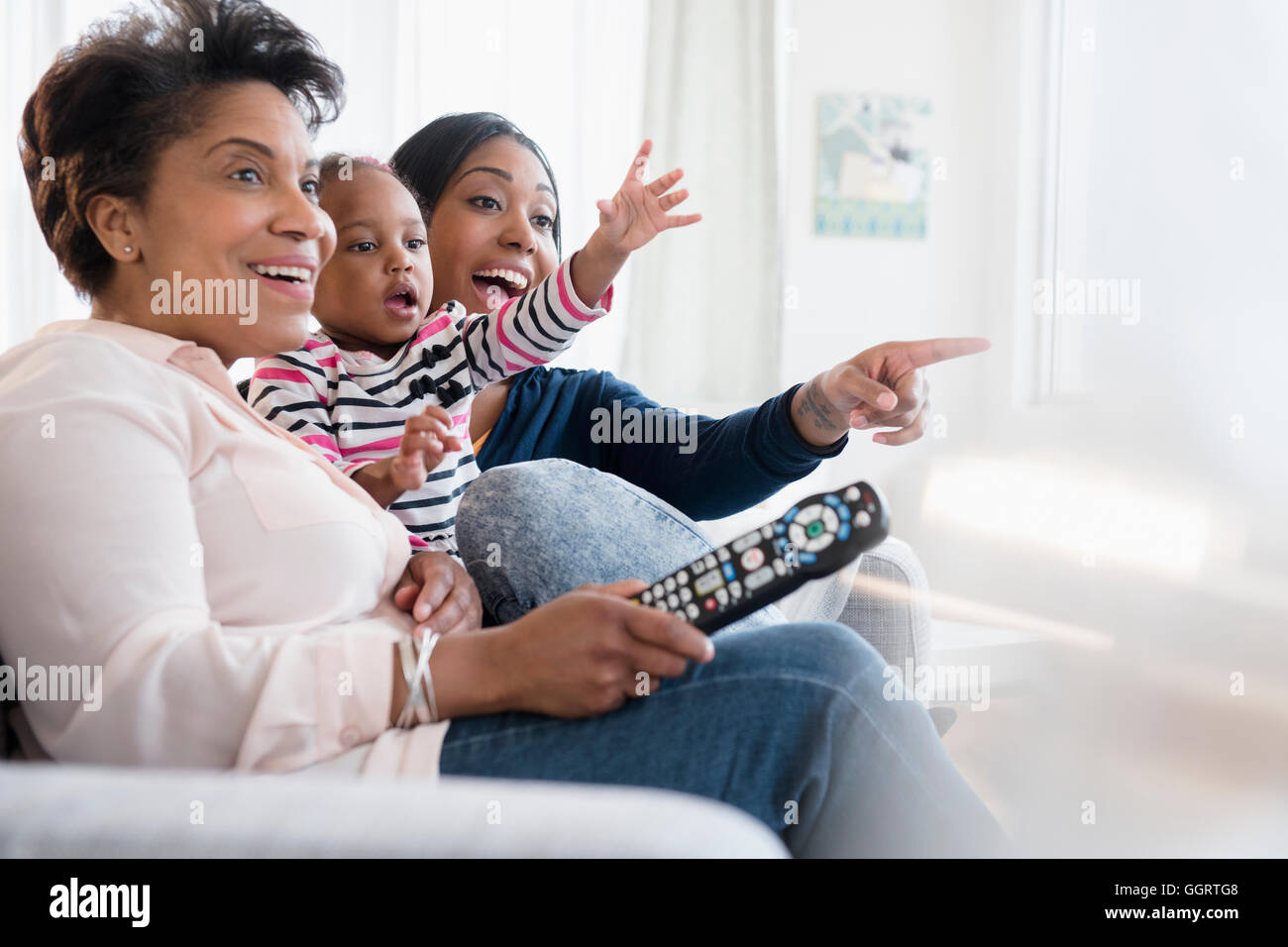 Nero multi-generazione famiglia eccitante guardare la televisione Foto Stock