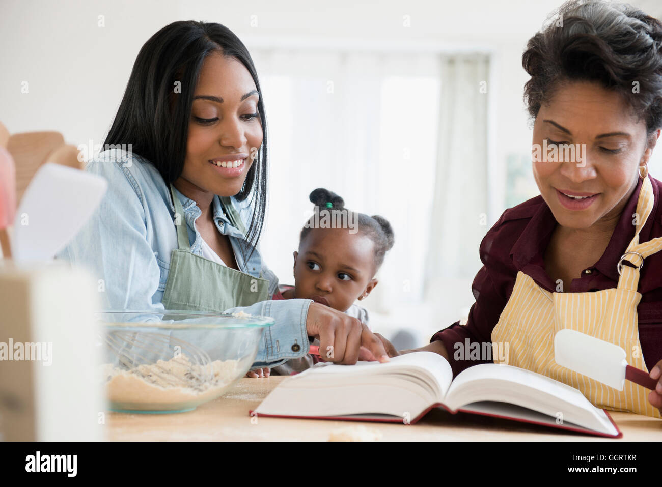 Nero multi-generazione famiglia ricetta di lettura nel libro di cucina Foto Stock