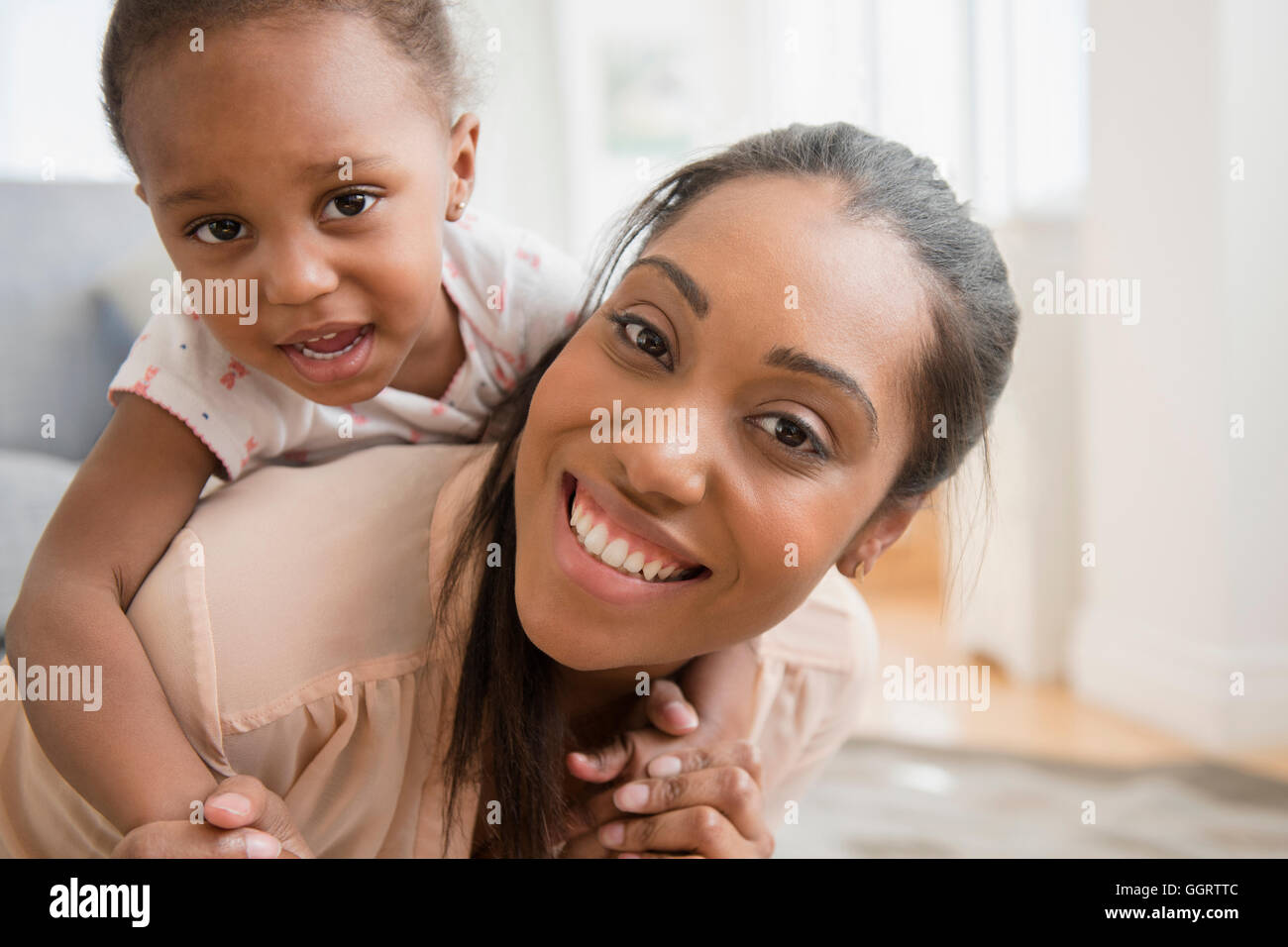 Madre nera bambino portando la figlia piggyback Foto Stock