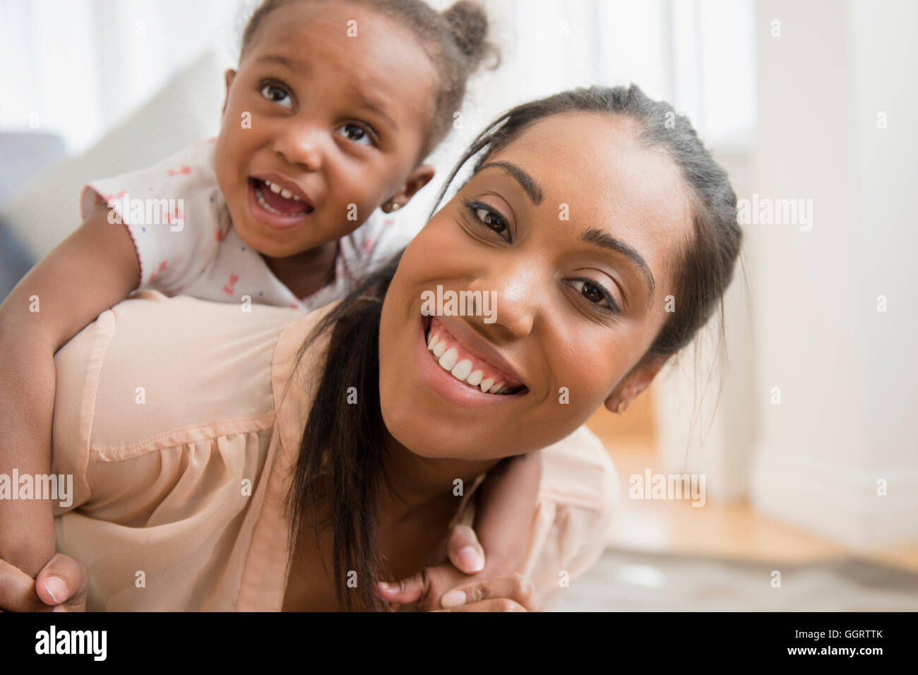 Madre nera bambino portando la figlia piggyback Foto Stock