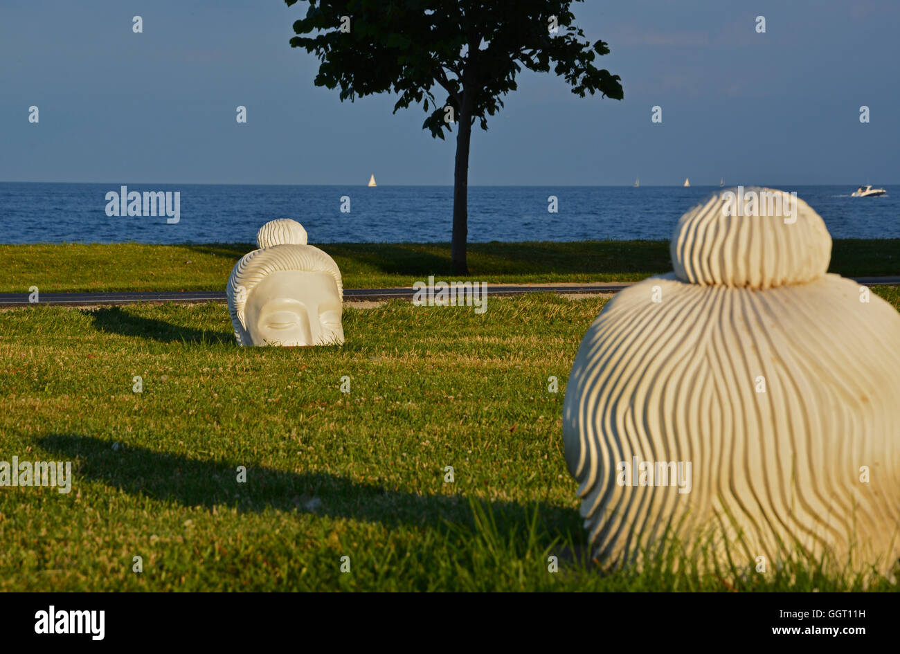 Un cerchio di teste di fronte al lago in Lincoln Park vicino a Fullerton Ave è parte dell'arte pubblica in Chicago Foto Stock