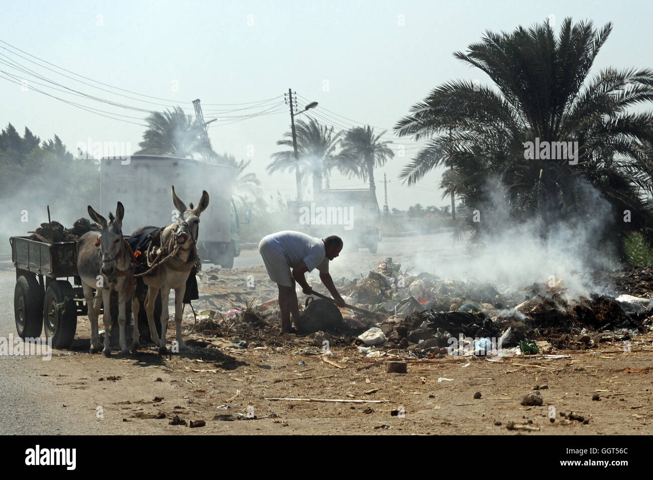 Spazzatura & garbage sul fuoco in Il Cairo Egitto con un uomo che cerca di mettere fuori Foto Stock