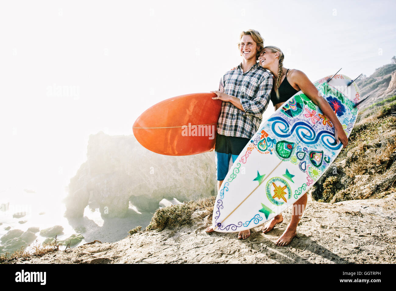 Coppia caucasici che trasportano le tavole da surf in spiaggia Foto Stock