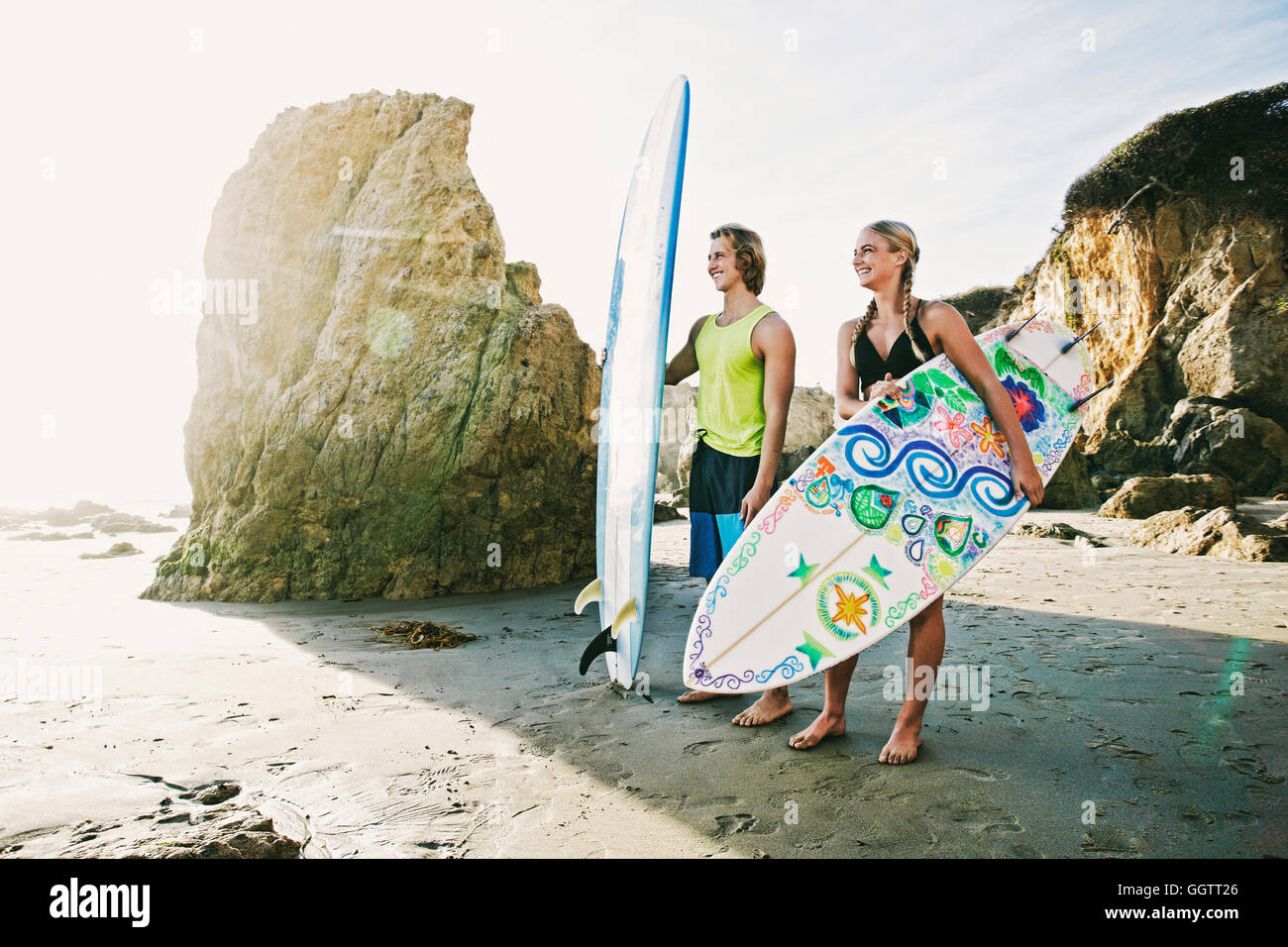 Coppia caucasici che trasportano le tavole da surf in spiaggia Foto Stock