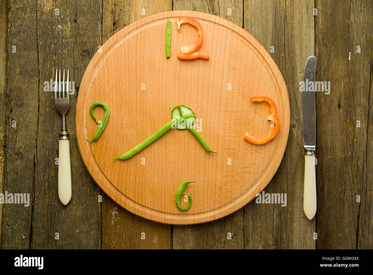 Orologio fatto da verdure sono sul tagliere. Foto Stock