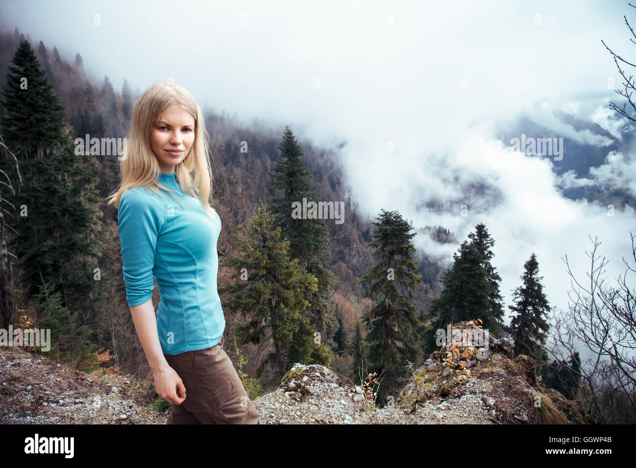 Giovane donna a piedi uno stile di vita all'aperto concetto di viaggio foggy foresta montagne sullo sfondo Foto Stock