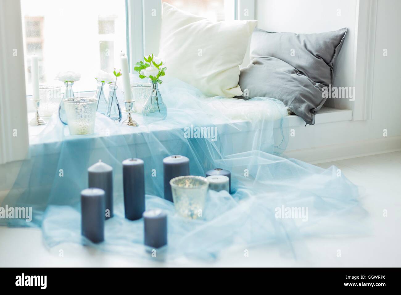 Il decor di photostudio candele grigio, bianco e cuscini, tessile blu Foto Stock