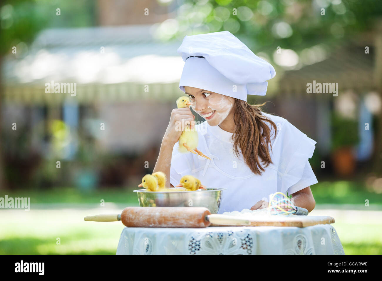 Sorridente little chef holding anatroccoli durante la cottura all'aperto Foto Stock