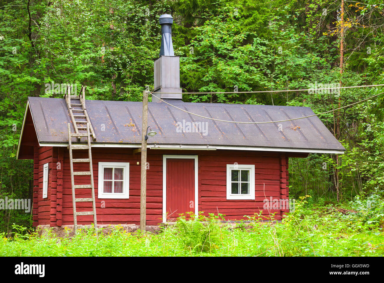 Tradizionale scandinavo red casa in legno sulla foresta verde dello sfondo. Kotka, in Finlandia Foto Stock