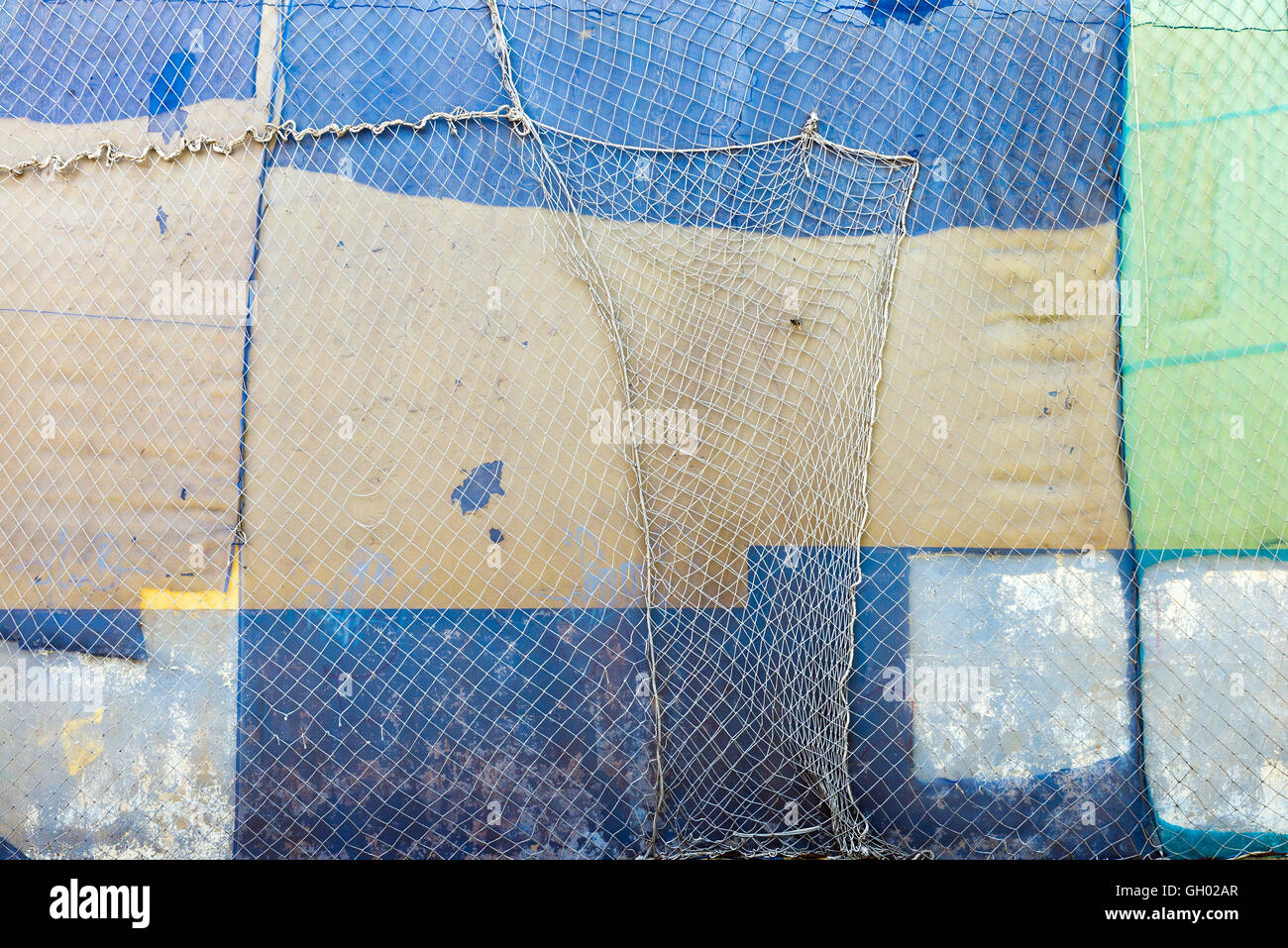 Vecchio abbandonato e martoriata facciata dettaglio di un muro sporco e coperto da una rete rovinoso Foto Stock