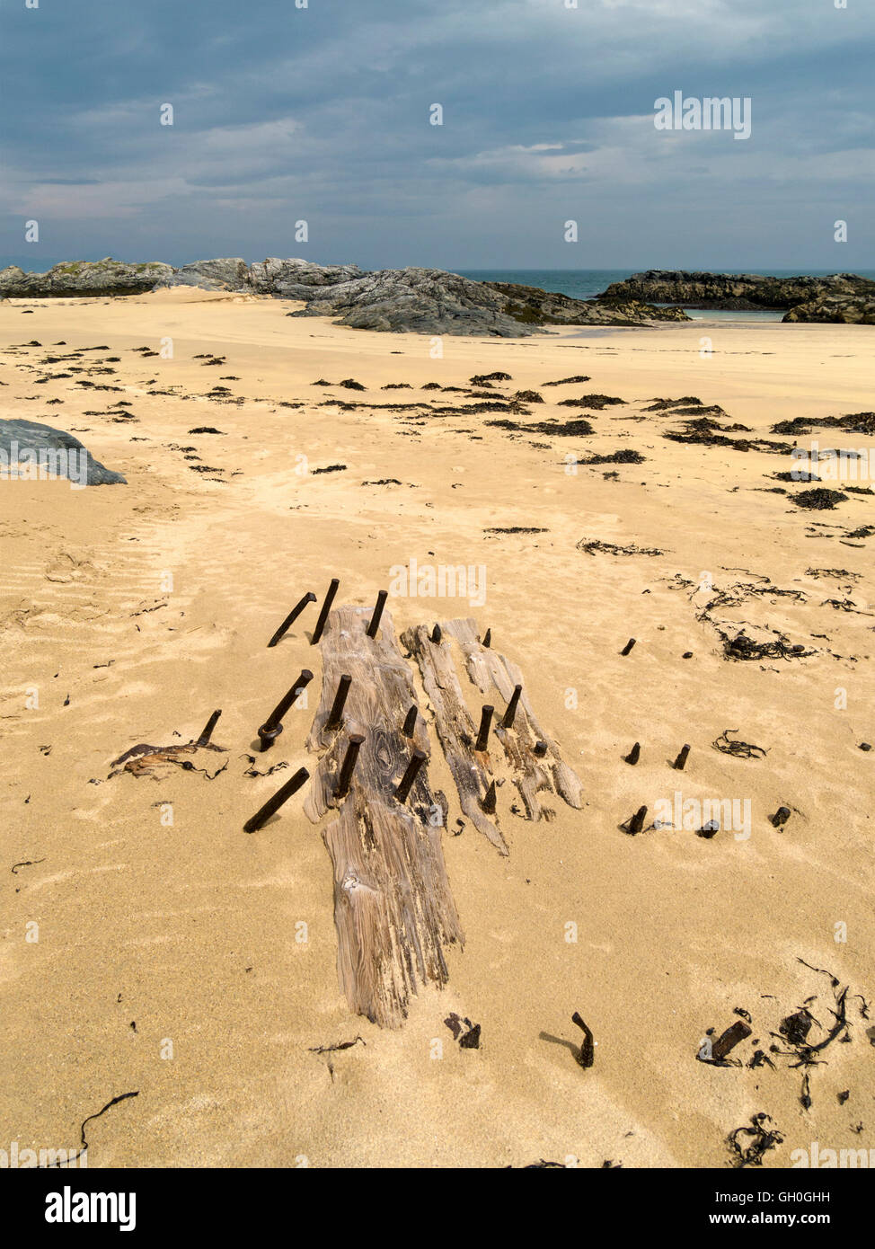 Distrutto vecchia nave di legno il legname e chiodi arrugginiti sepolto nelle sabbie della spiaggia Balnahard, Isola di Colonsay, Scotland, Regno Unito. Foto Stock