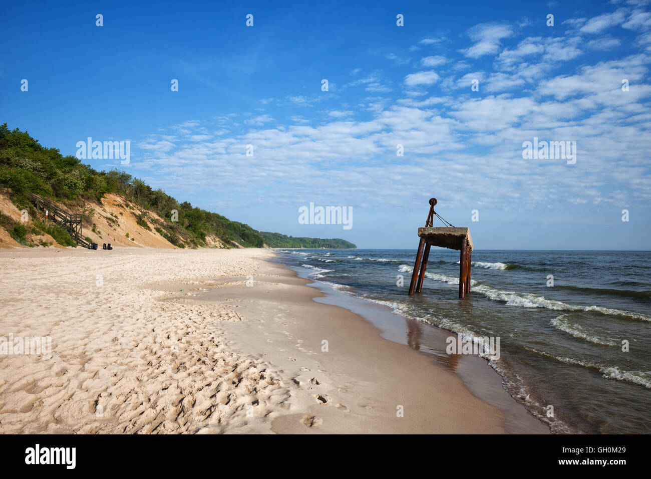 Lunga spiaggia di sabbia bianca a Mar Baltico in Chlapowo, vicino Wladyslawowo in Polonia, gru vecchia struttura arrugginito sull'acqua Foto Stock