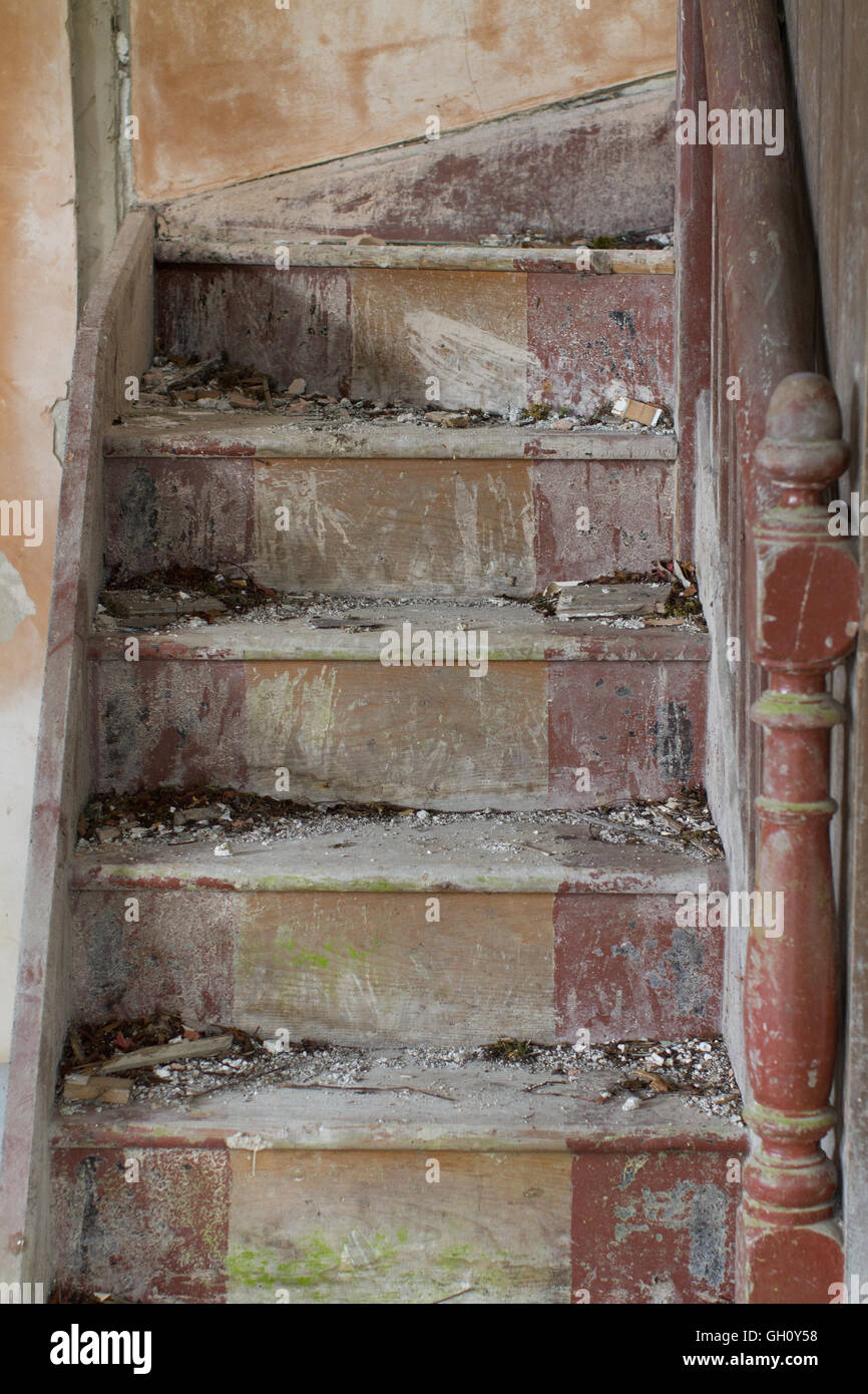 Colpo verticale di un dimenticato scala di legno interna vuota una casa abbandonata. Foto Stock