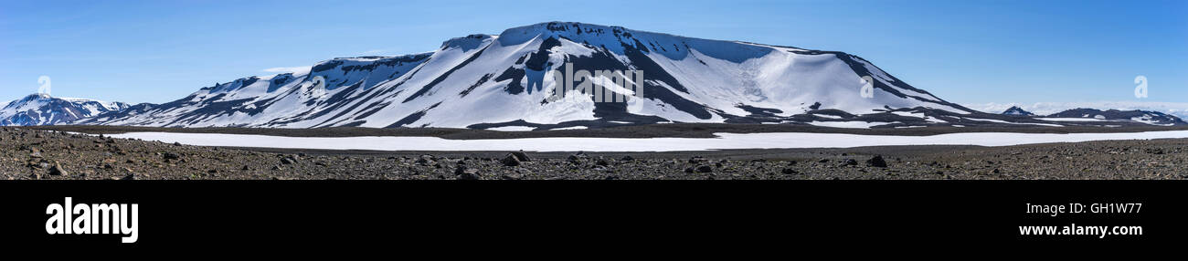 Panorama vulcanico, sud highlands Occidentali Islanda. Coperta di neve vulcano in un paesaggio arido contro un cielo blu Foto Stock