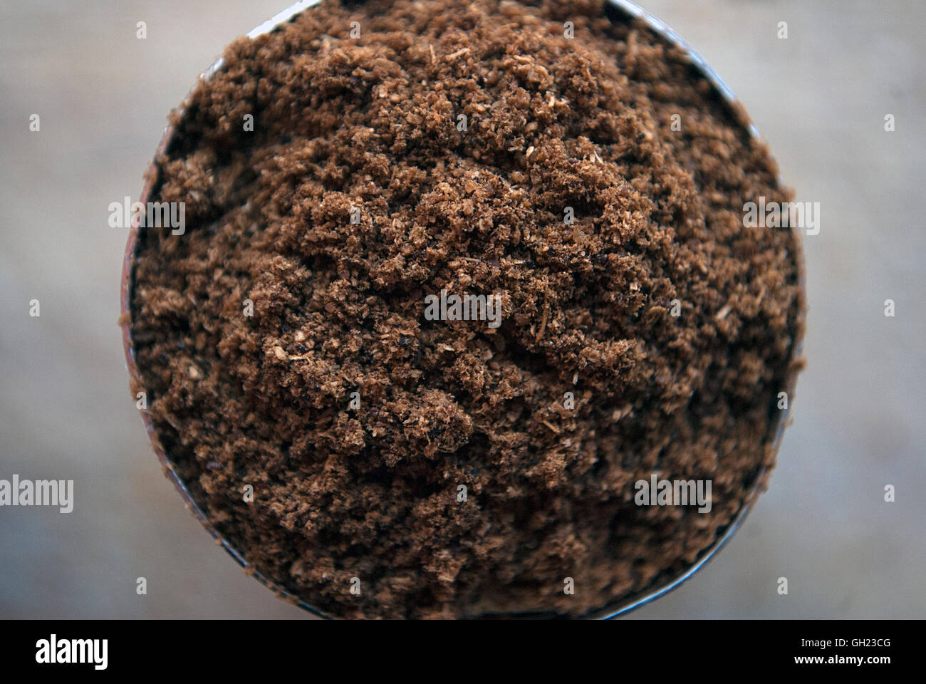 Macro shot di Garam Masala spice in un contenitore di metallo su una tavola di legno Foto Stock