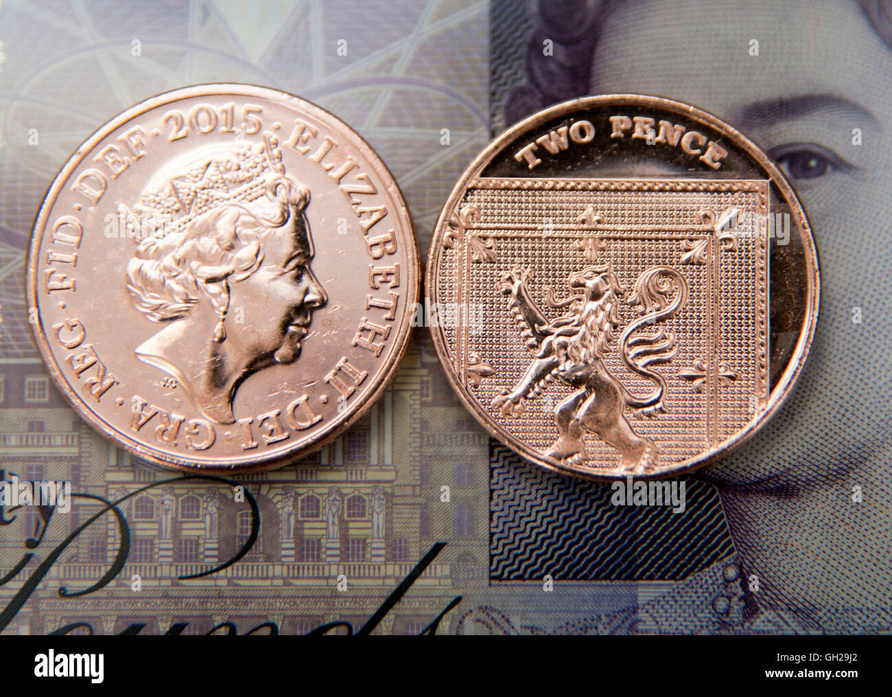 Due pence monete su venti pound nota, Londra Foto Stock