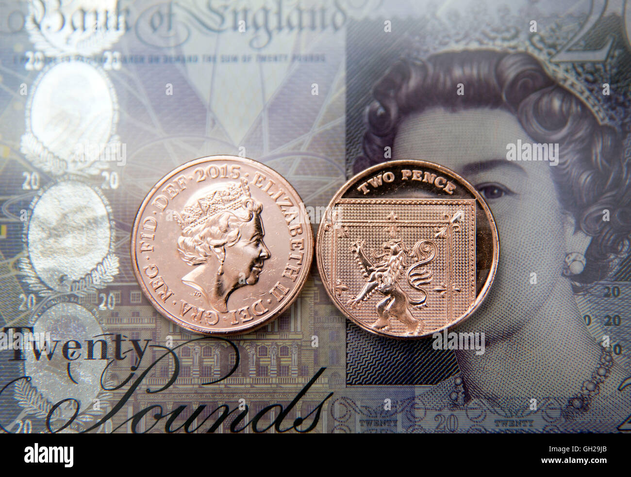 Due pence monete su venti pound nota, Londra Foto Stock