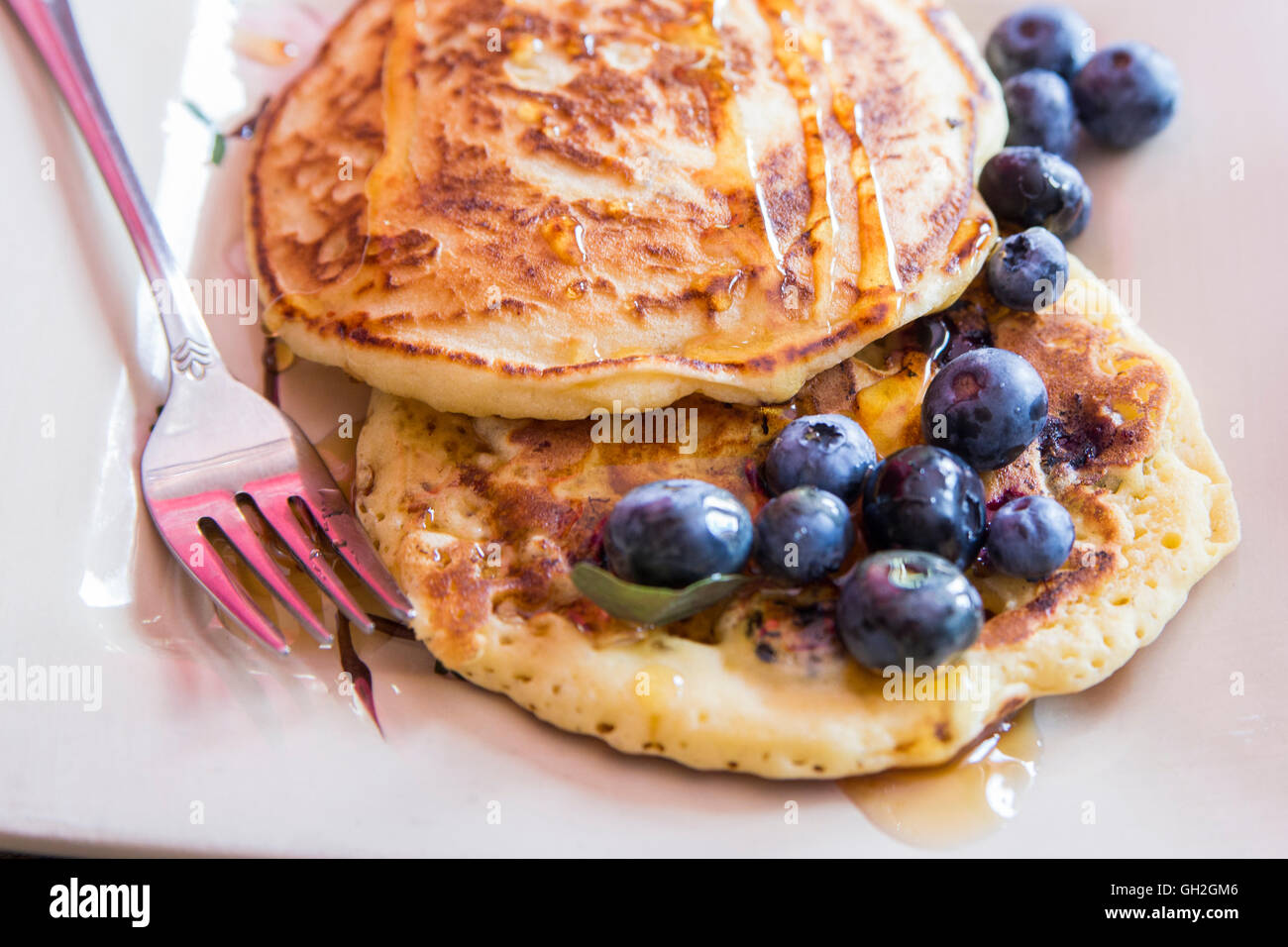 Gustose frittelle closeup con mirtilli e sciroppo d'acero guarnire. Foto Stock