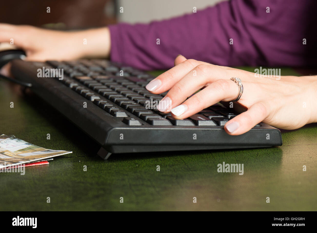 Donna di mano alla tastiera digitando al lavoro Foto Stock