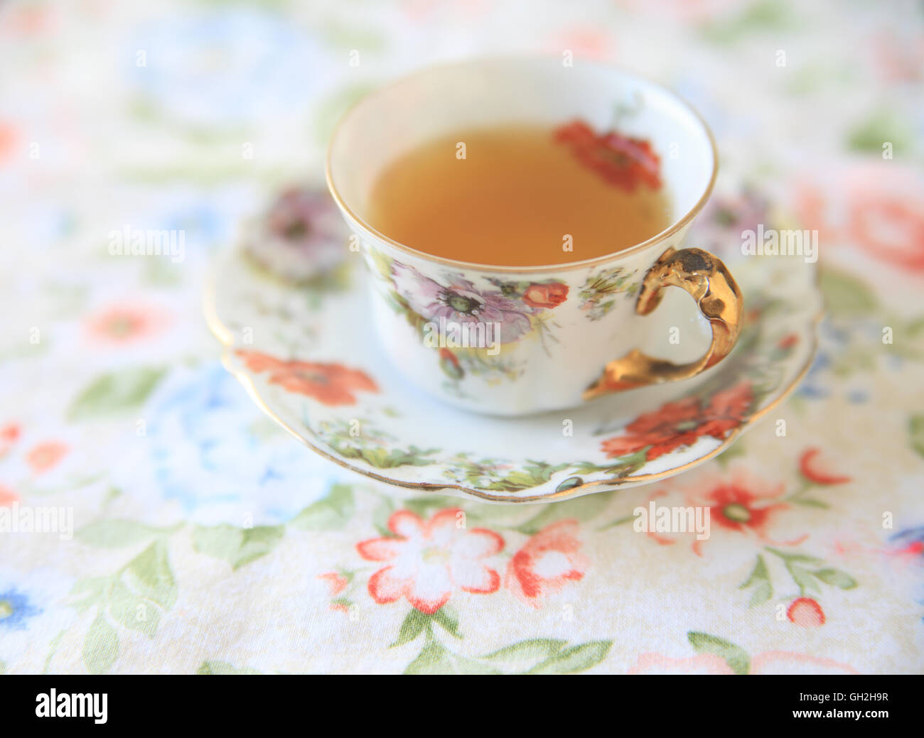 Coppa floreale con tè su un panno floreali Foto Stock