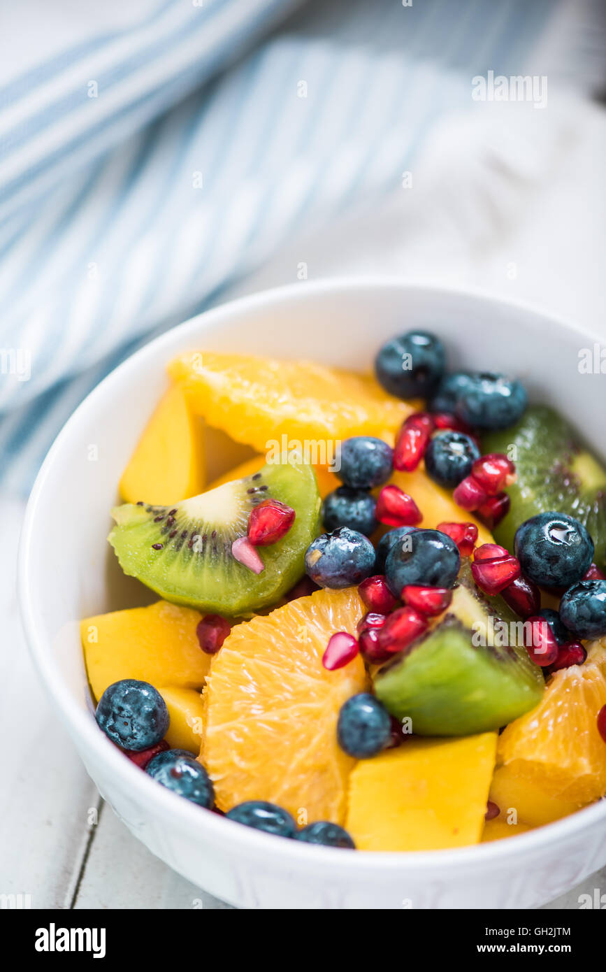 La colazione ciotola con insalata di frutta, con frutti di bosco, mango,kiwi e melograno Foto Stock