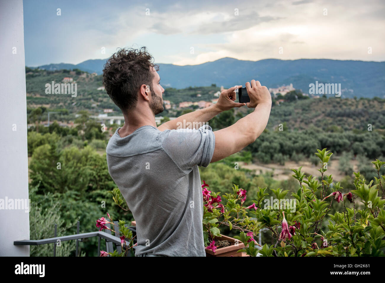 Bel giovane uomo prendendo foto con il telefono cellulare del paesaggio Foto Stock