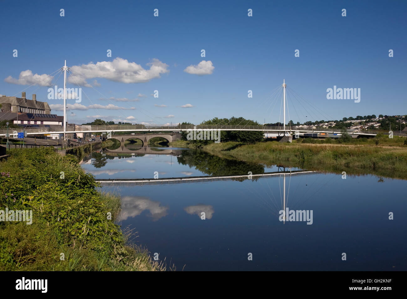 Le calme acque del fiume Towy a Carmarthen con piede e ponti stradali Foto Stock