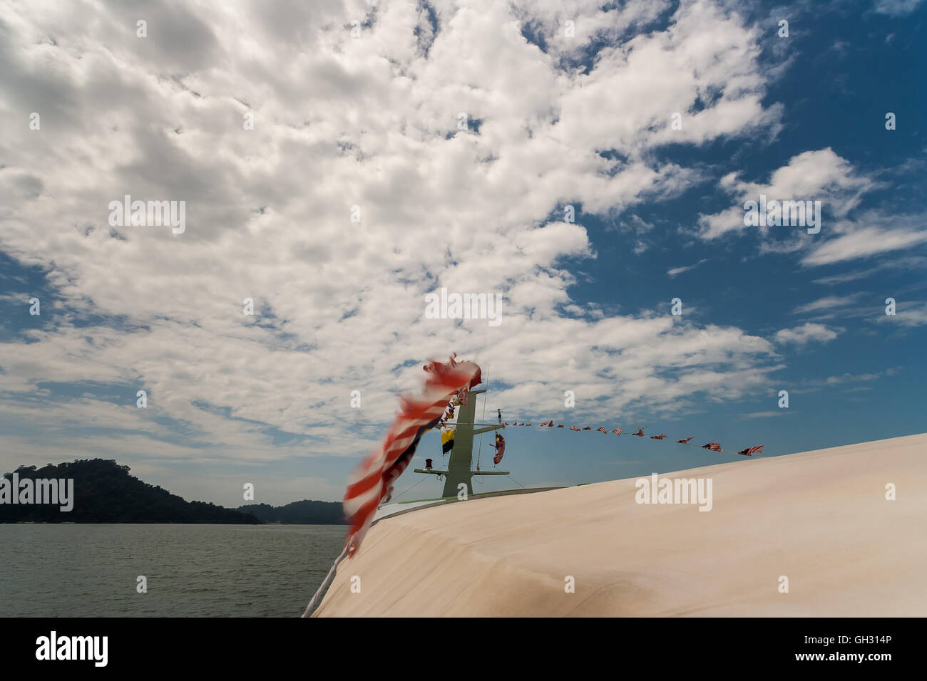 Gita in barca sul Borneo Malese. Le bandiere sono sbattimenti nel vento. Foto Stock