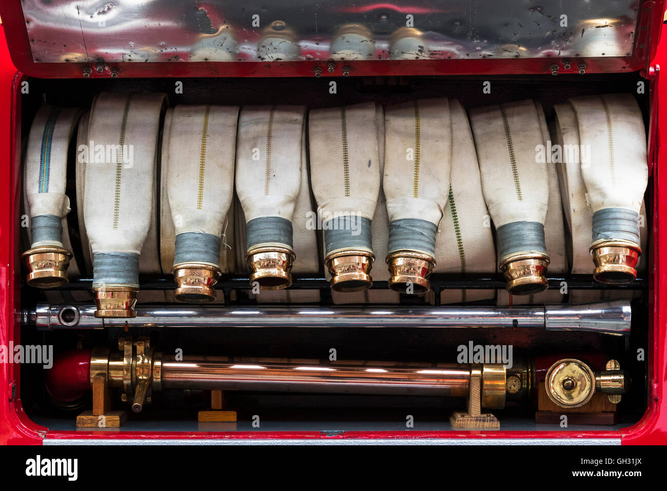 I tubi flessibili di tela e accoppiamento in ottone su un annata 1937 motore Fire Foto Stock