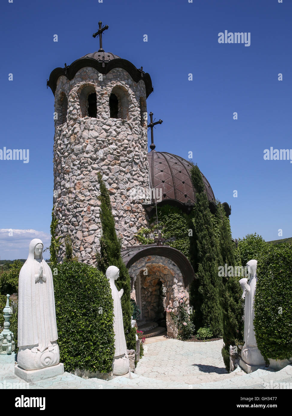 Piccola chiesa con sculture sotto il bel cielo Foto Stock