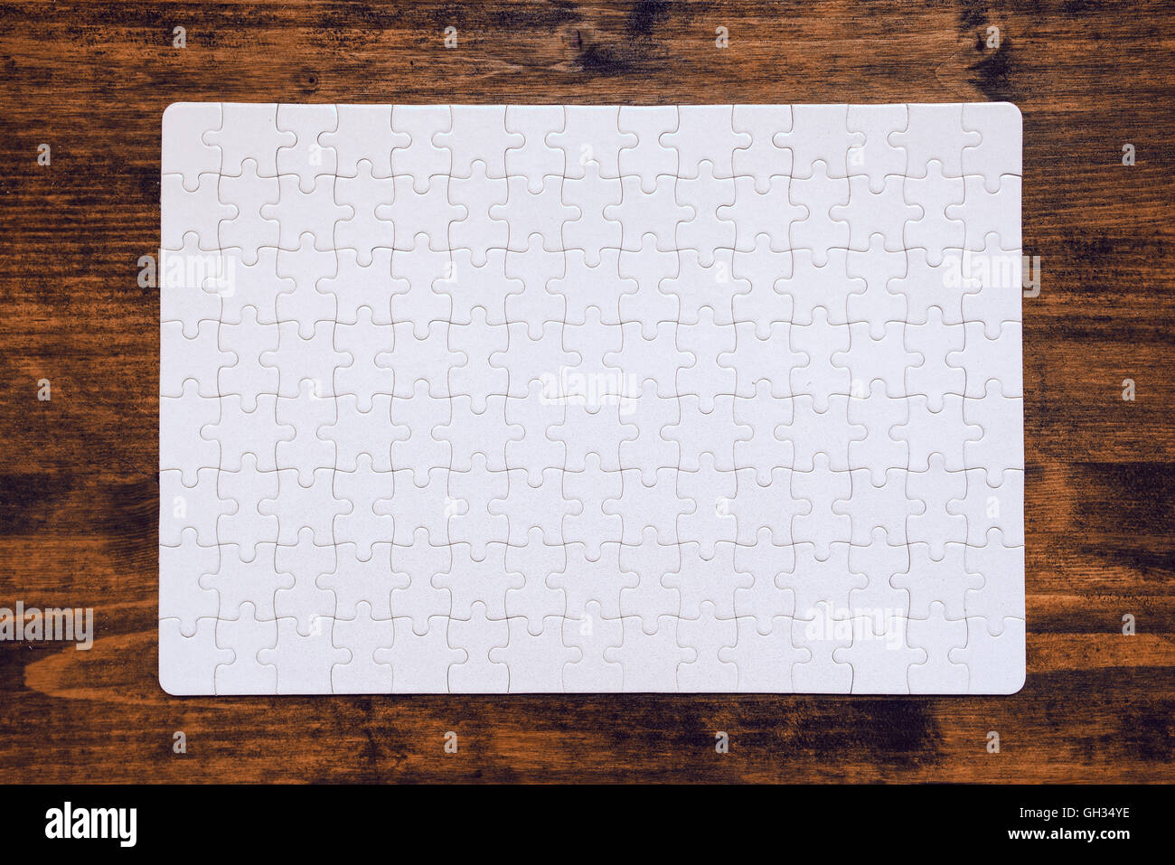 Completato puzzle come copia di spazio disposto sulla scrivania in legno, vista dall'alto Foto Stock