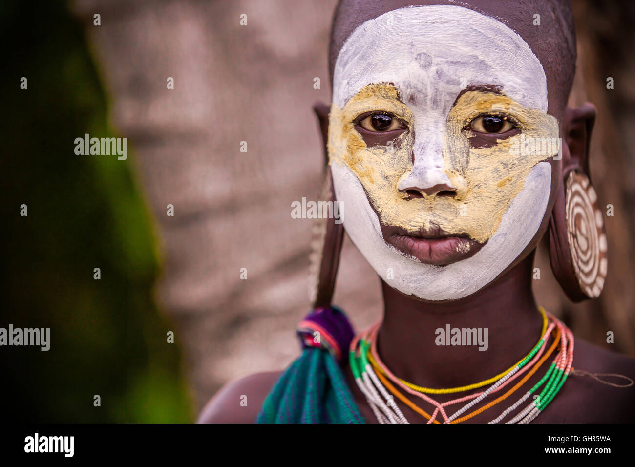 Giovane ragazza di Suri tribe con tradizionale bodypainting ed orecchini Foto Stock