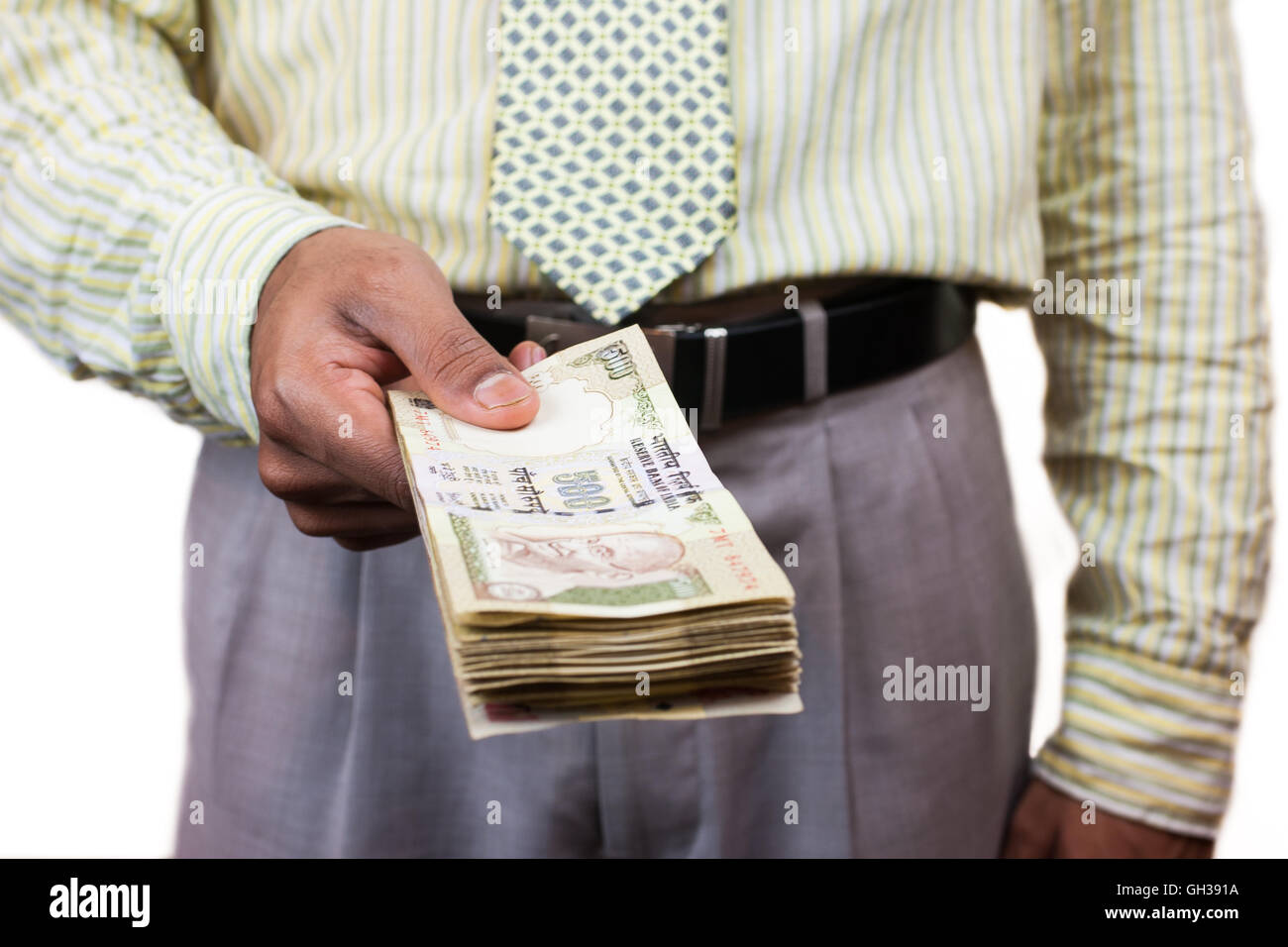 Un Asian business man tenendo fuori una pila di 500 rupee note. Foto Stock