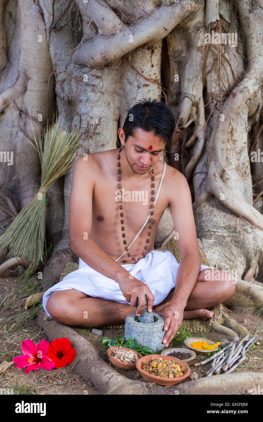 Un giovane medico indiano la preparazione tradizionale ayurvedico, alle erbe, medicina. Foto Stock