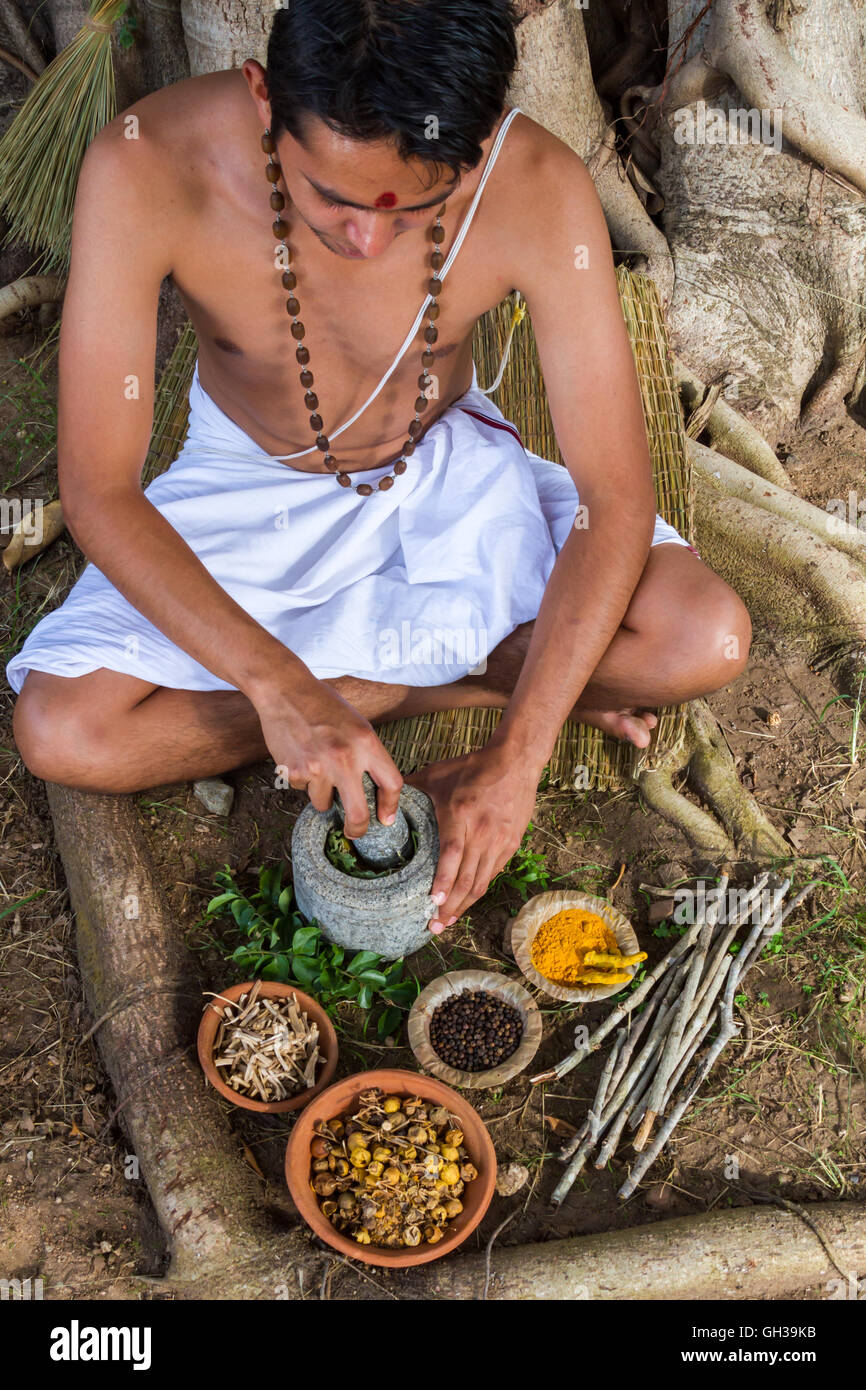 Un giovane medico indiano la preparazione tradizionale ayurvedico, alle erbe, medicina. Foto Stock