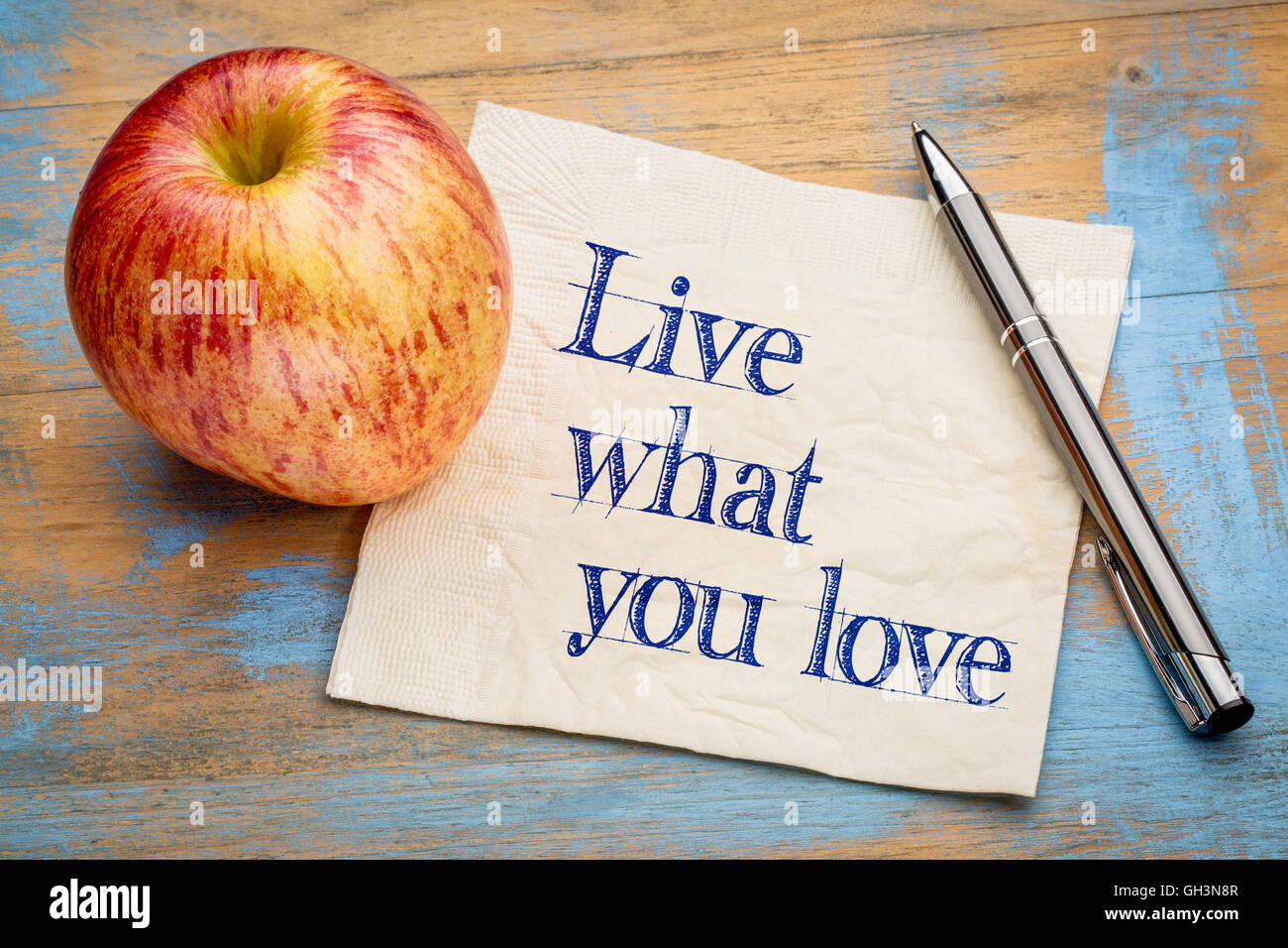 Vivere ciò che è amore - scrittura su un tovagliolo con un fresco apple Foto Stock
