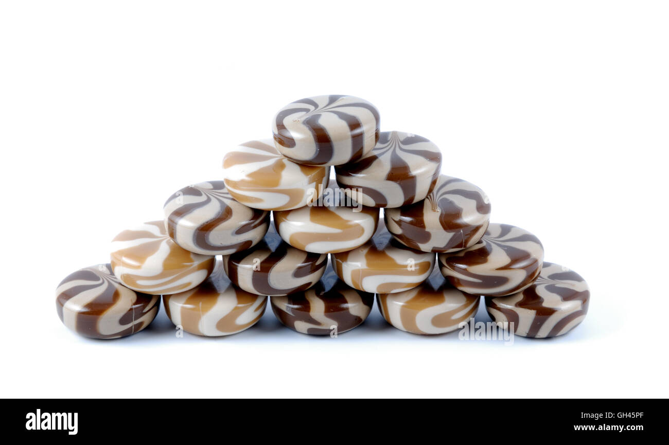 Il cioccolato cremosa di dolci caramelle di zucchero stabilite da una collina su uno sfondo bianco Foto Stock