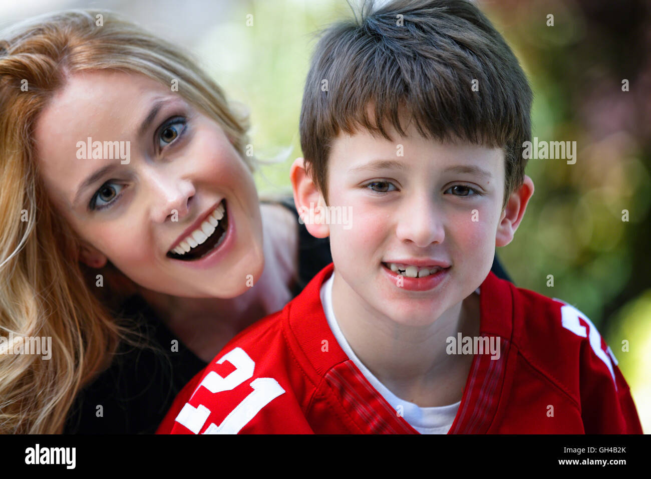 Outdoor Ritratto di una madre e figlio di guardare avanti e sorridente Foto Stock