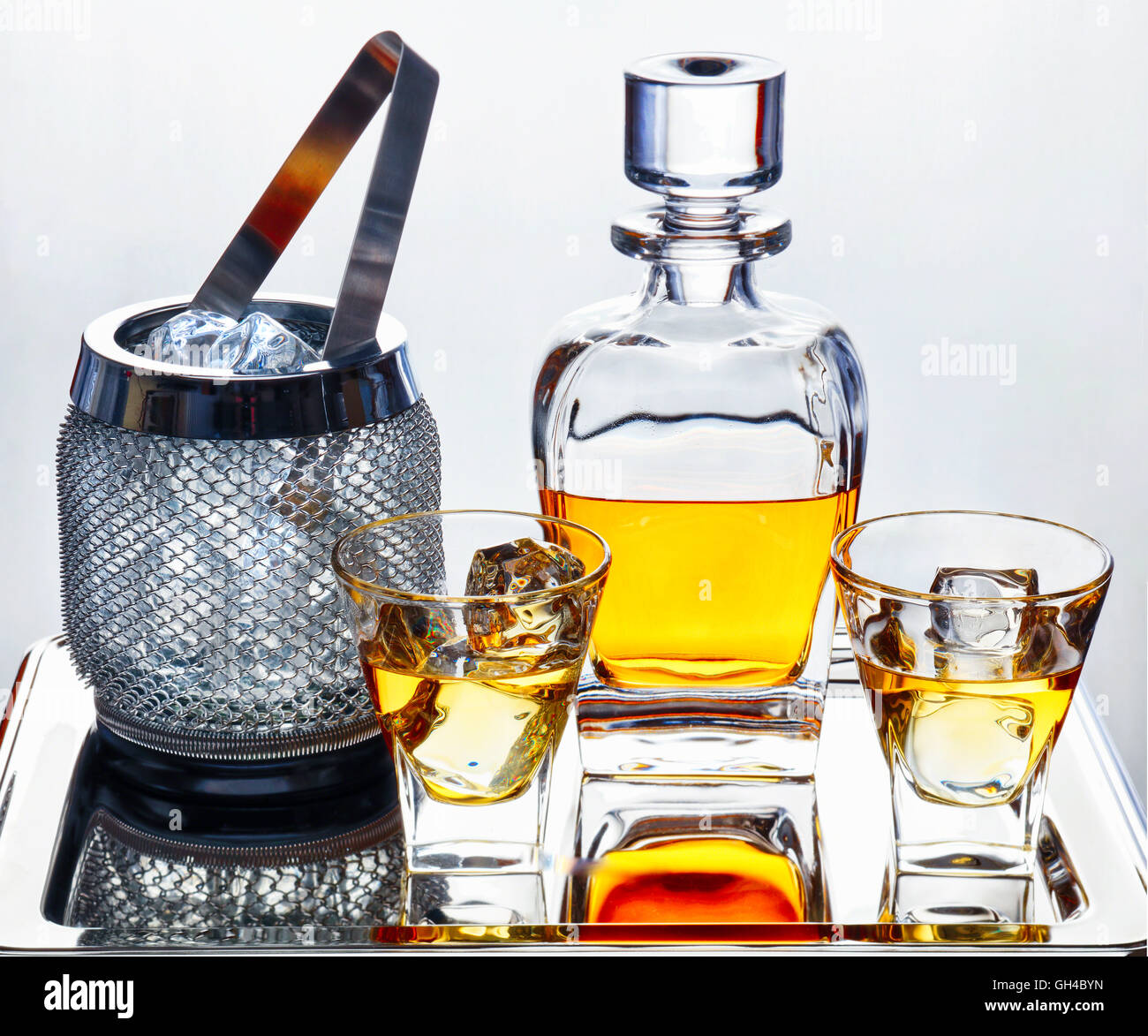 Il whiskey in tradizionale Decanter e bicchieri con cubetti di ghiaccio e il secchiello del ghiaccio su un vassoio d'argento Foto Stock