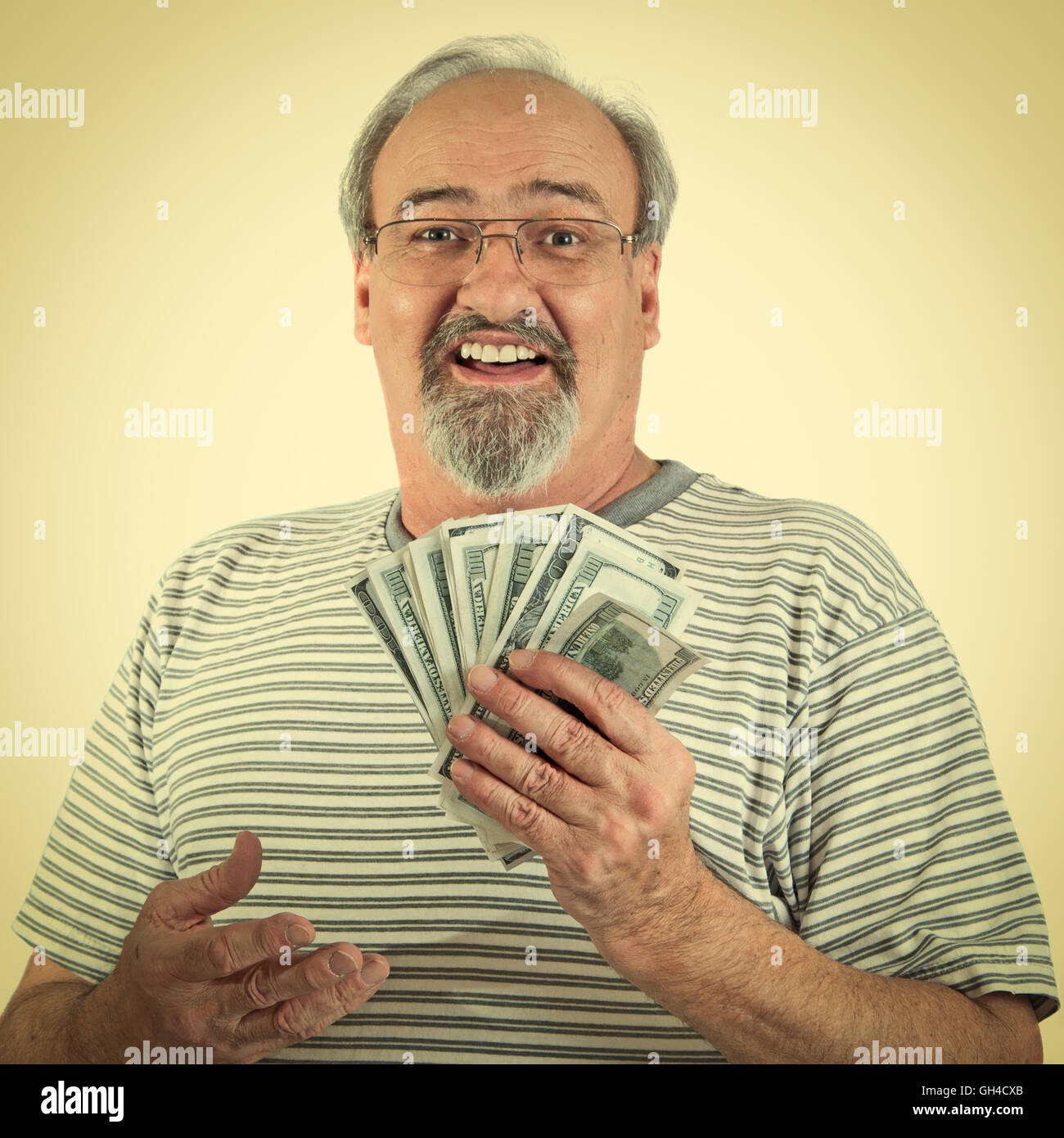 Uomo maturo sorrisi mentre tiene una manciata di American Hundred Dollar Bills. Instalgram retrò guardare. Foto Stock