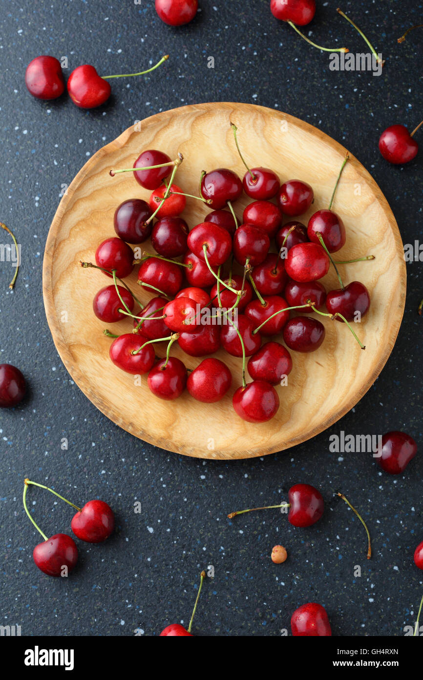 Le ciliege fresche sul piatto di legno. Cibo vista superiore Foto Stock