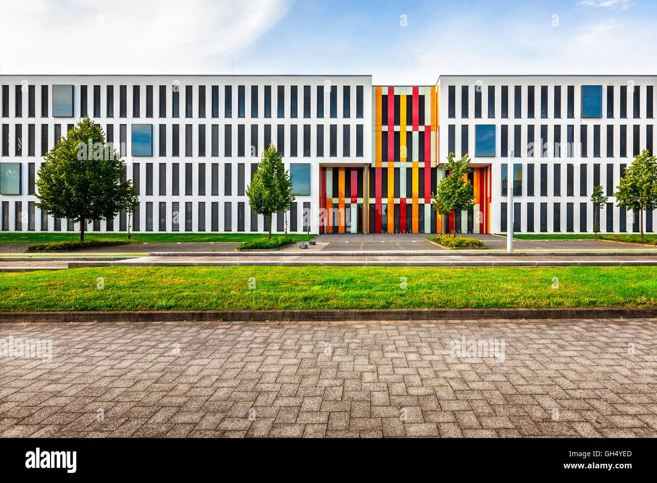 Nuova e moderna di office o college school esterno dell'edificio. Cortile interno con parcheggi, prato, alberi e strada Foto Stock