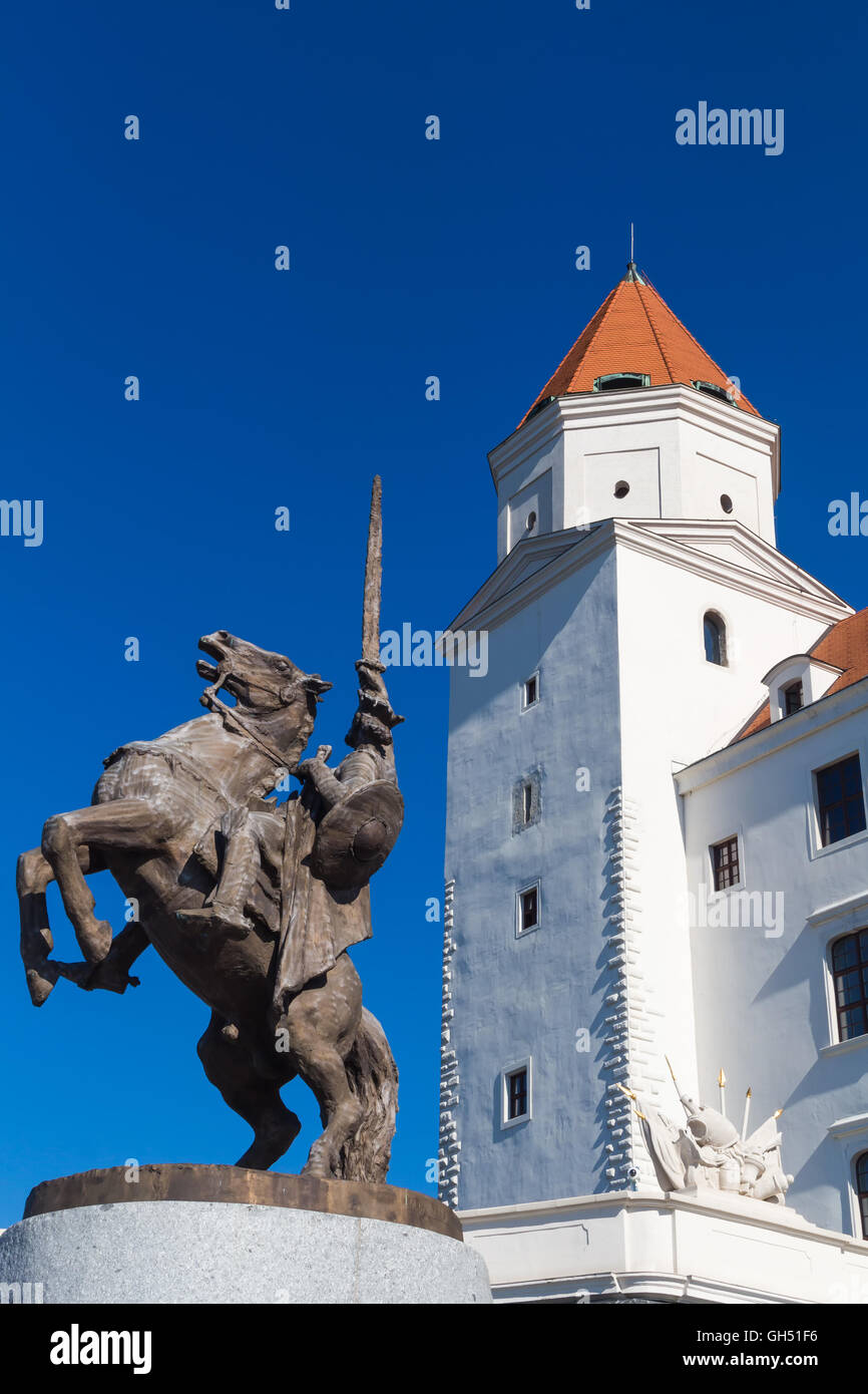Torre sul angolo del castello di Bratislava. In primo piano la statua di Re Svatopluk su un cavallo. Luminose blu cielo estate. Foto Stock