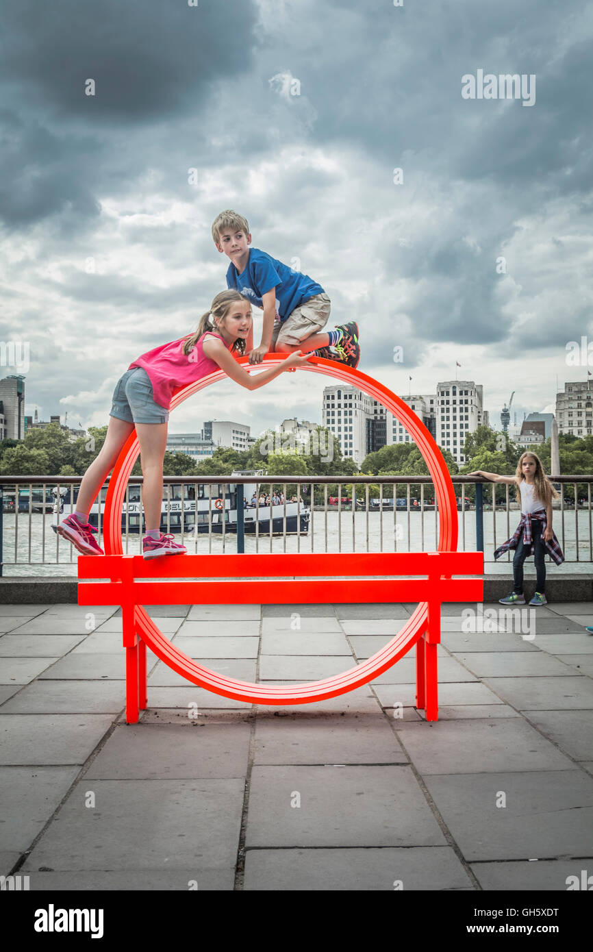 Bambini che giocano su uno dei da Jeppe Hein modificati di banchi sociale a Londra il South Bank, SE1, Regno Unito Foto Stock