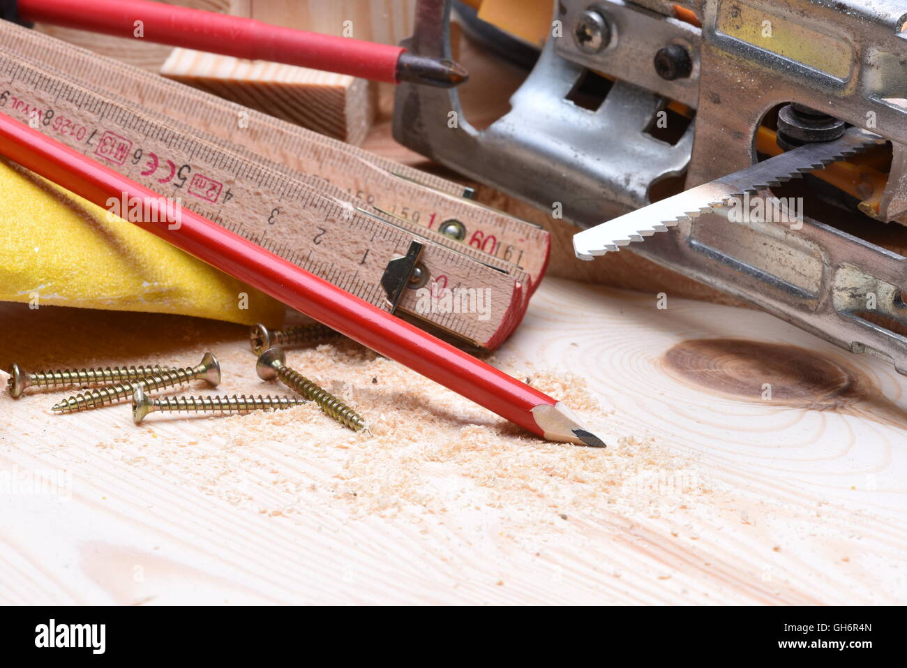 Close up di attrezzi di falegnameria e seghetto alternativo elettrico sul pannello di legno Foto Stock