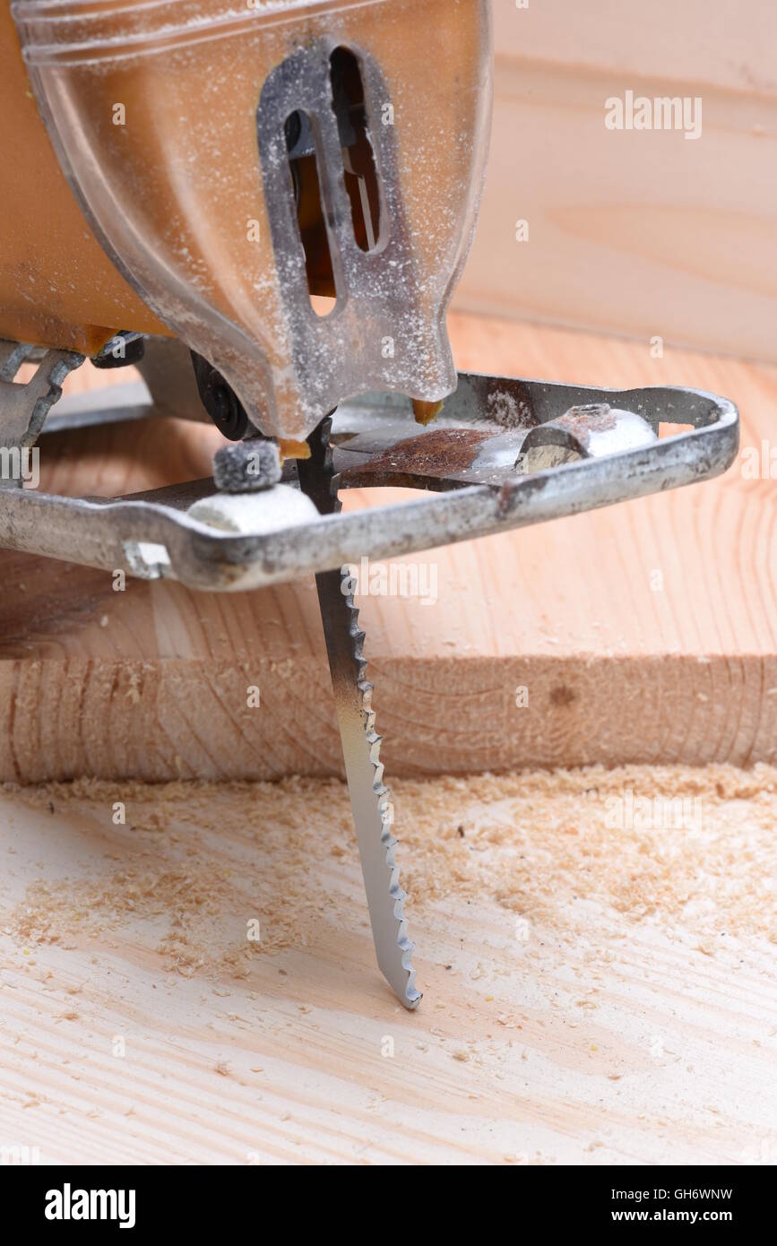 Seghetto alternativo elettrico con tavola di legno vicino fino Foto Stock