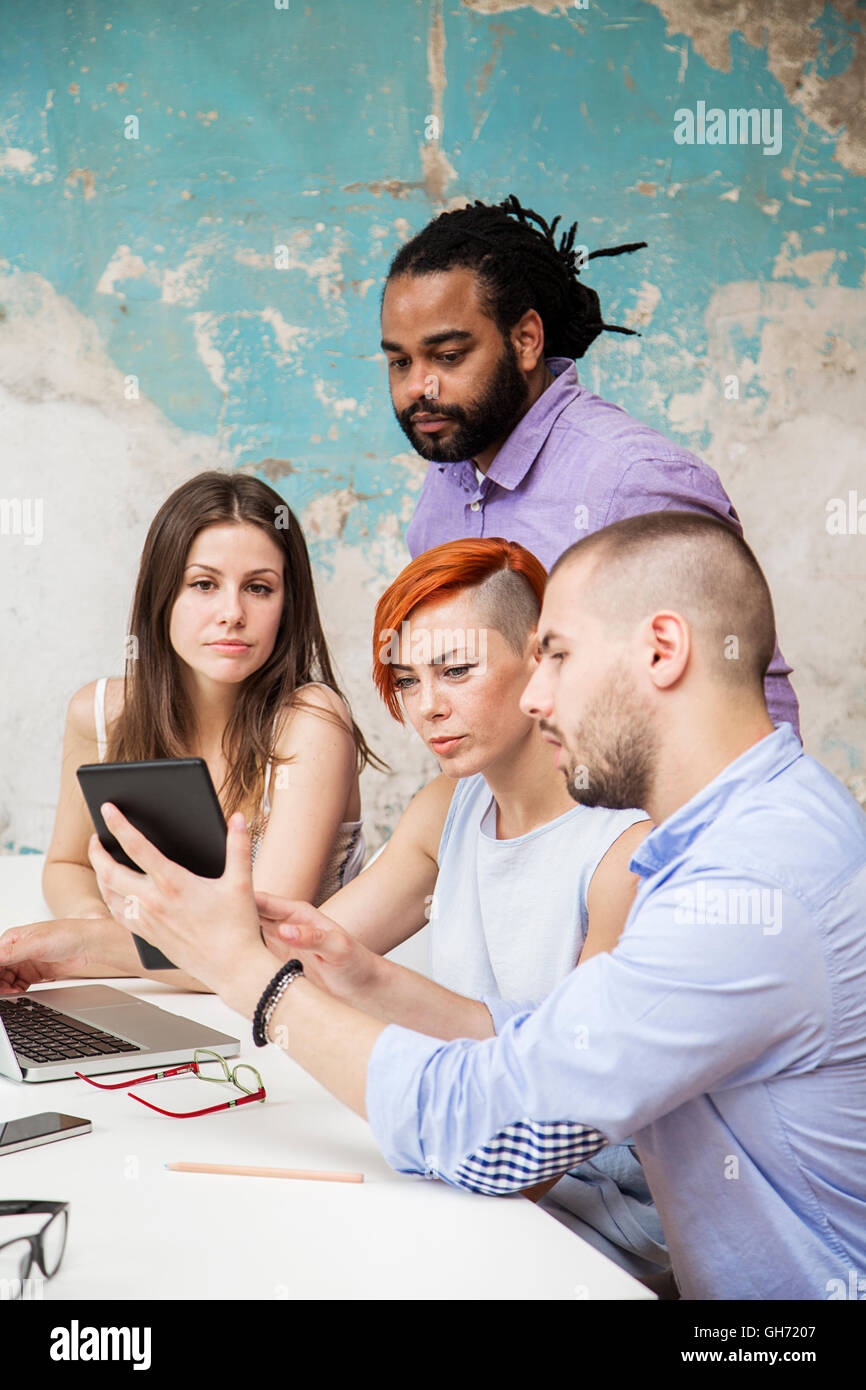 Giovani che lavorano con la scrivania in ufficio grunge Foto Stock