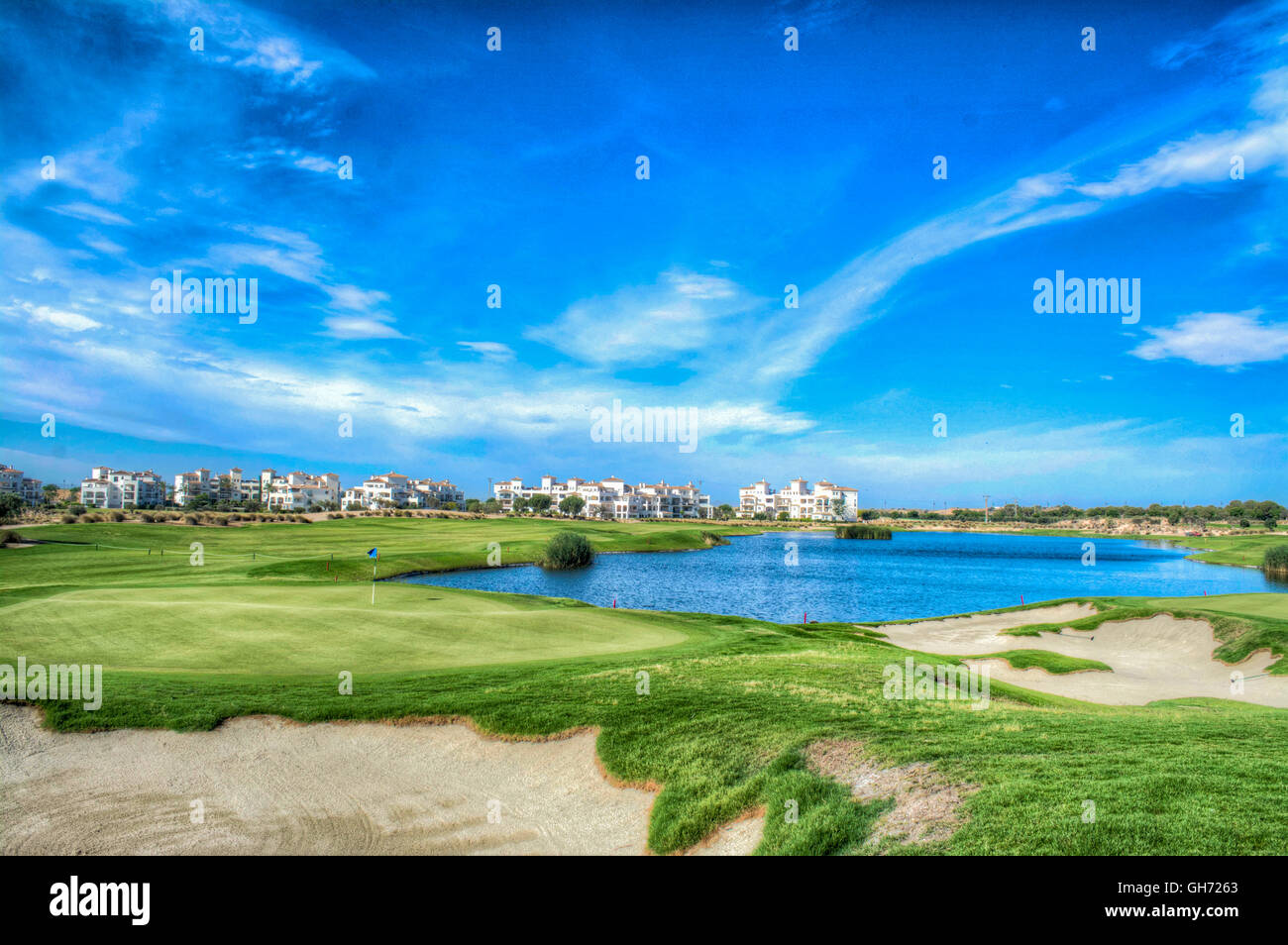 Vista HDR oltre la diciottesima green, bunker e pericolo in acqua alla Hacienda Riquelme Golf Resort, Murcia, Spagna Foto Stock